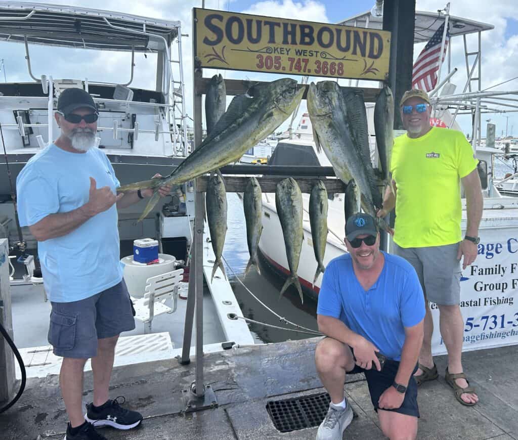 3 men with the days catch of Mahi at the dock