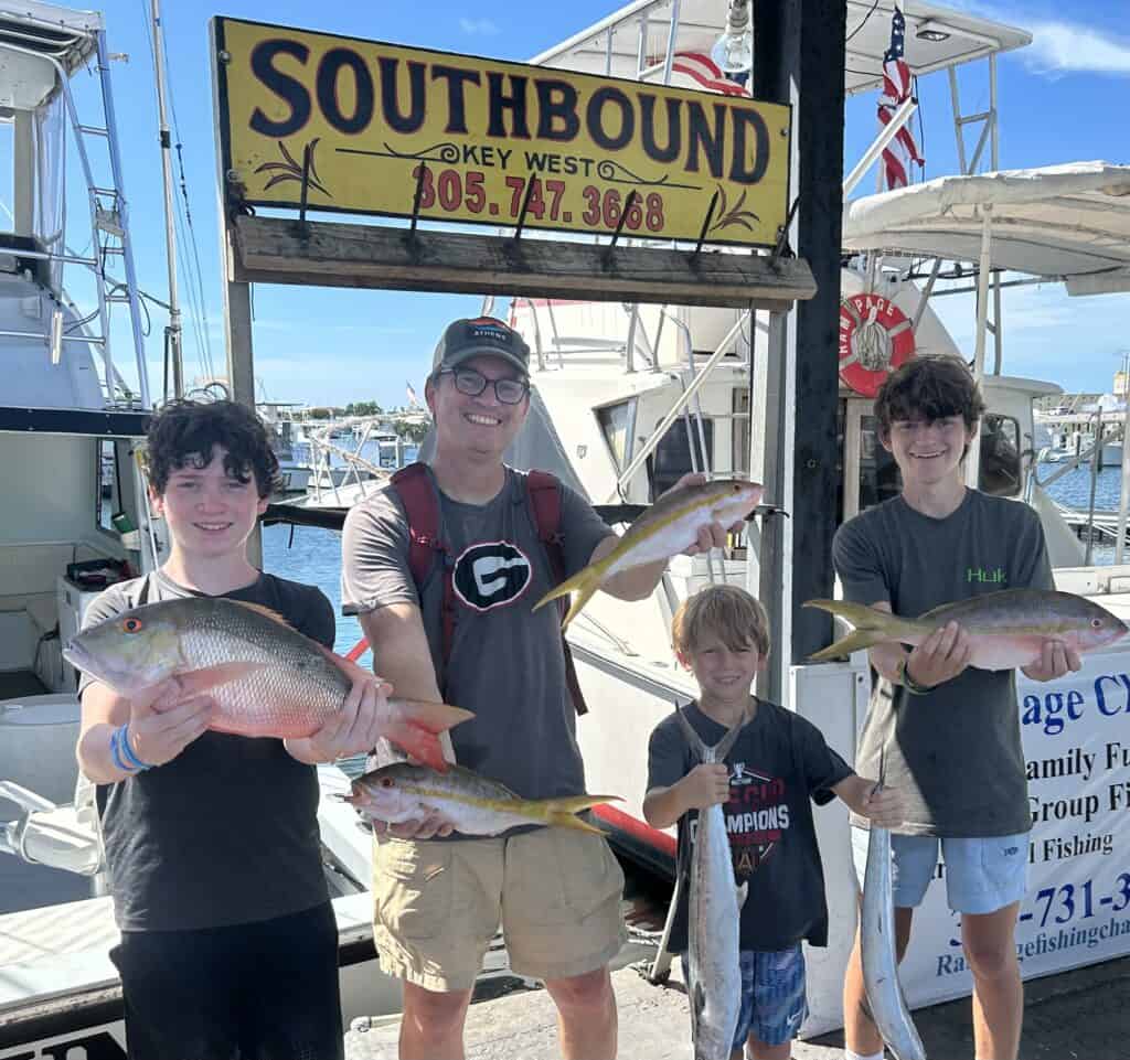 Father and sons holding some of the fish they caught on the Charter Boat Southbound in Key West, Florida