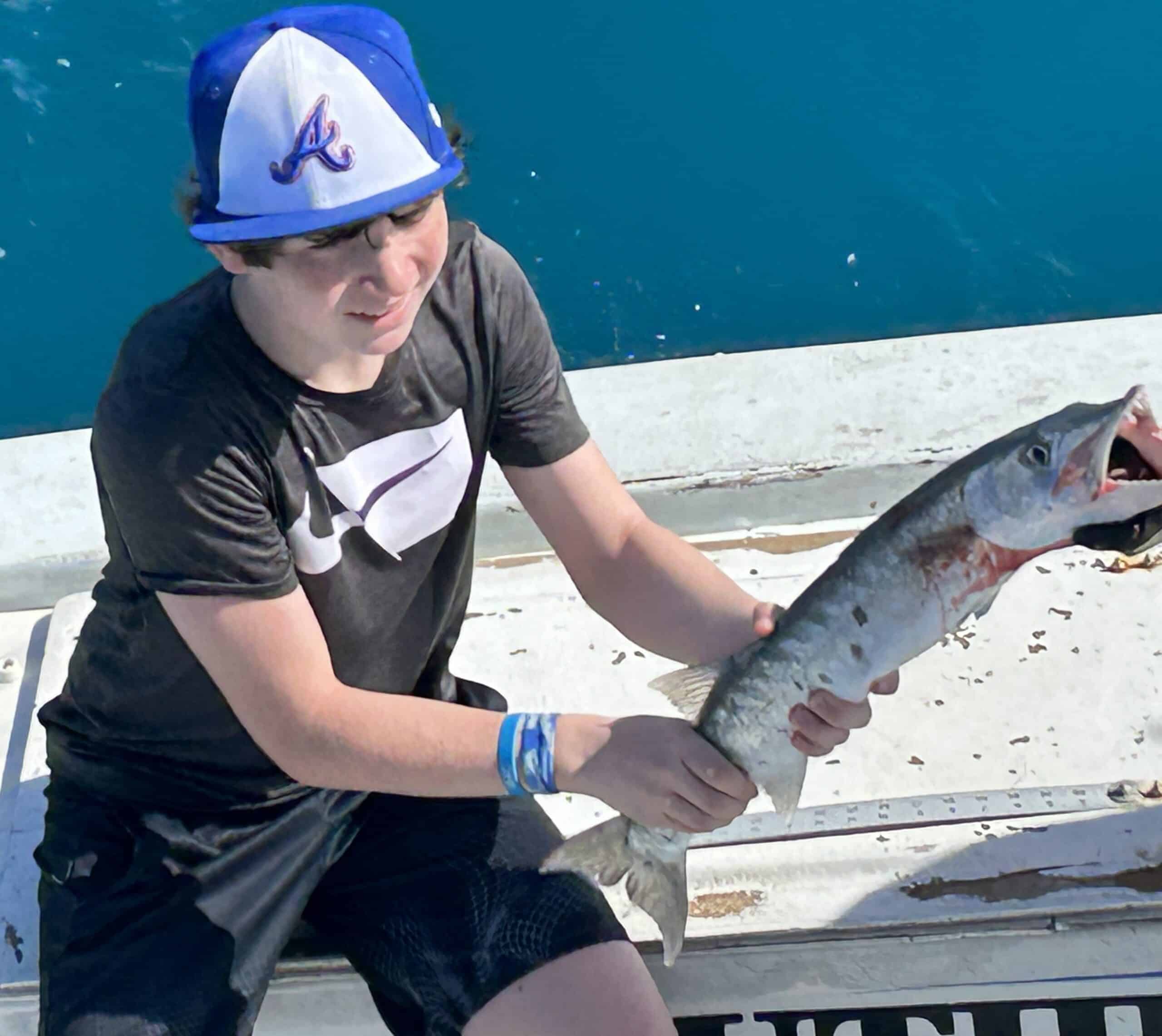 Boy holding a barracuda he caught on the Charter Boat Southbound