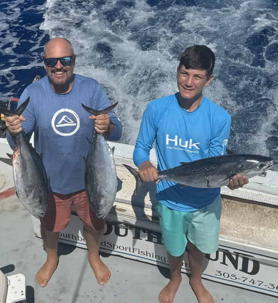 June 25 Group father and son holding fish on the back deck of the Southbound