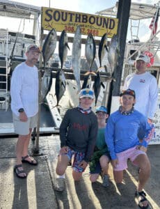 Fatheres and their boys at the dock with a rack full of fish