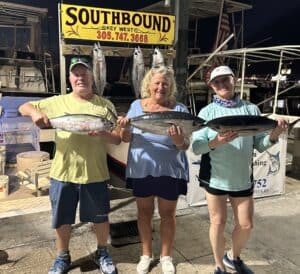 Three anglers holding Black Fin Tuna at the dock